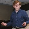 Photo of Alex questioning, shoulders shrugging